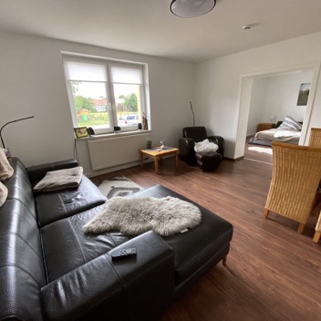 Wohnzimmer mit Ledercouch Relaxsessel und Sitzgruppe